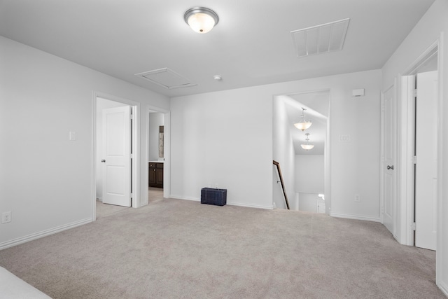 spare room with baseboards, carpet flooring, visible vents, and attic access