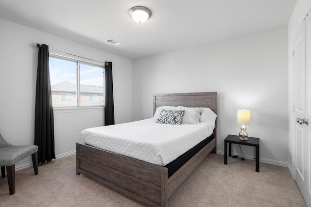 bedroom featuring baseboards, visible vents, and light colored carpet