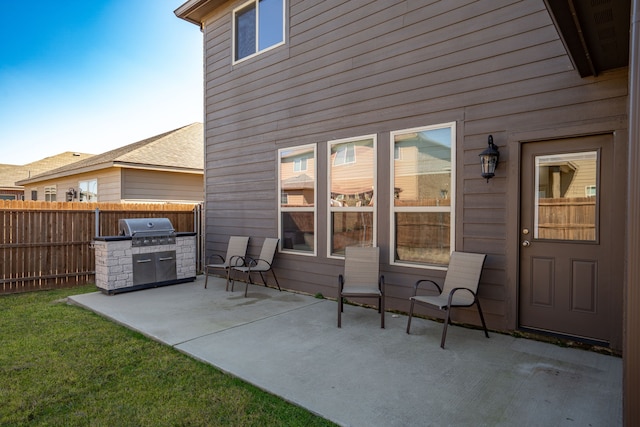 view of patio with area for grilling and fence