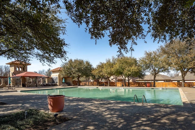 community pool featuring a gazebo, a patio, and fence