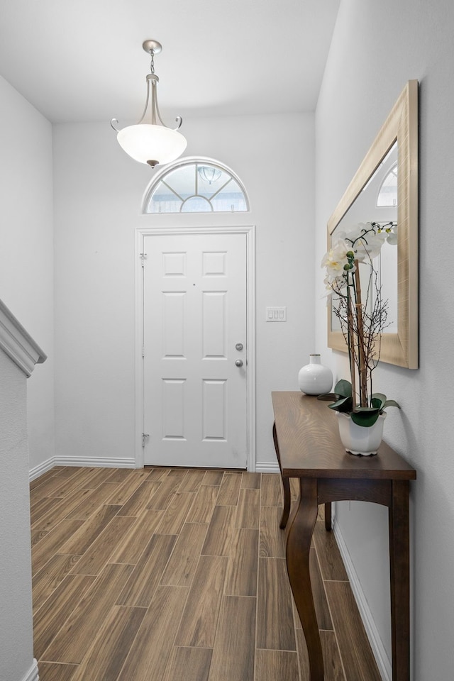 foyer featuring baseboards and wood finish floors