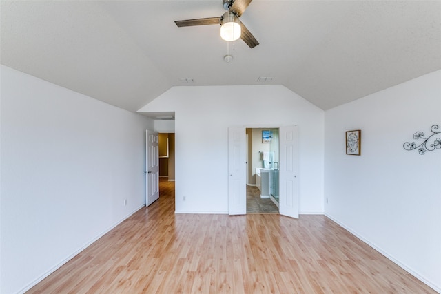 unfurnished room featuring lofted ceiling, visible vents, light wood-style floors, ceiling fan, and baseboards