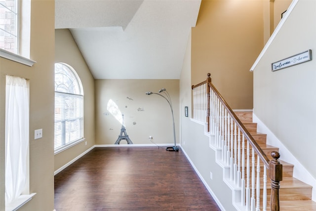 interior space featuring high vaulted ceiling, stairs, baseboards, and wood finished floors