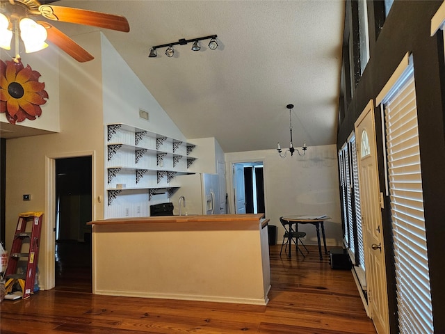 kitchen featuring white refrigerator with ice dispenser, visible vents, dark wood-type flooring, high vaulted ceiling, and ceiling fan with notable chandelier