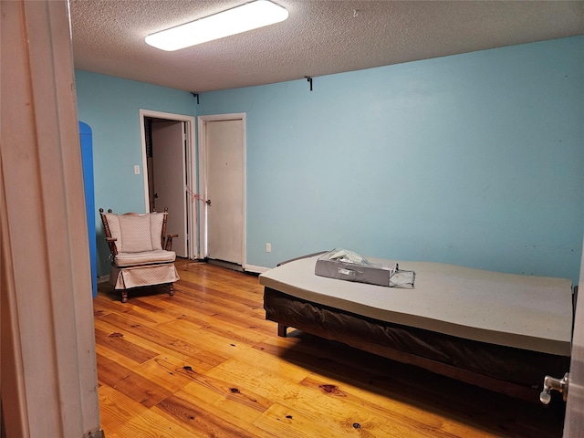 bedroom featuring wood-type flooring and a textured ceiling