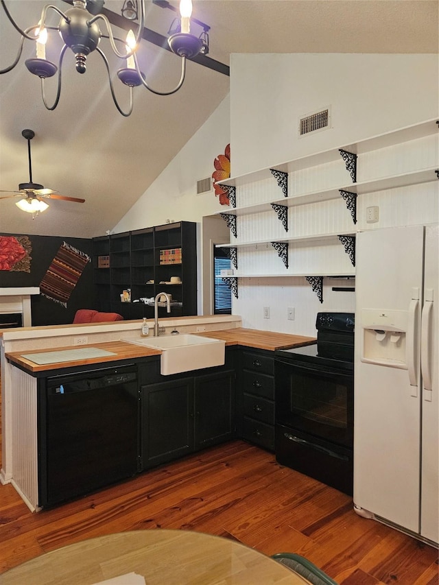 kitchen with visible vents, dark cabinetry, black appliances, open shelves, and a sink