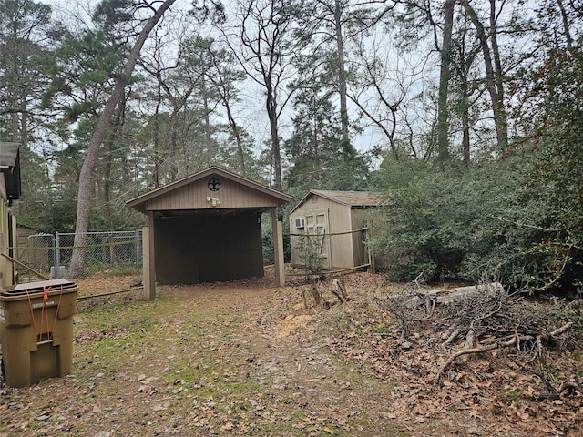 view of yard featuring a storage shed, fence, and an outbuilding