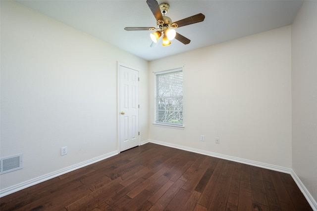 unfurnished room with dark wood-style floors, a ceiling fan, visible vents, and baseboards