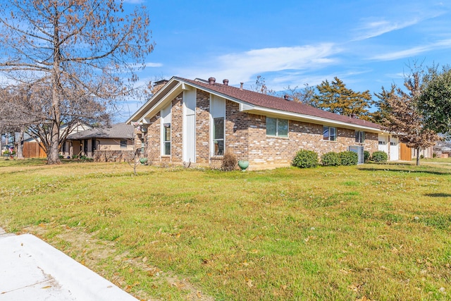 view of front of house with a garage, a front lawn, and brick siding