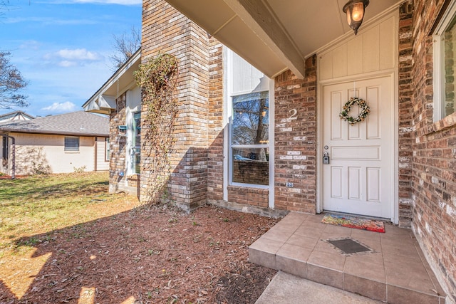 view of exterior entry featuring brick siding