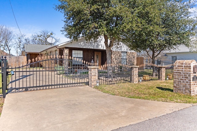 view of front facade featuring a fenced front yard, a gate, and concrete driveway