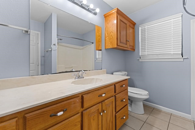 bathroom with tile patterned flooring, toilet, vanity, baseboards, and a shower