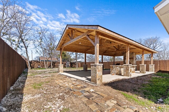 exterior space with a patio area, a fenced backyard, a gazebo, and an outdoor kitchen