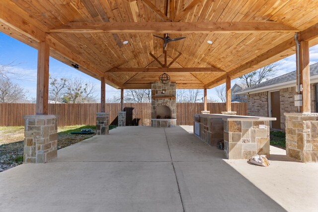 view of patio / terrace with a fenced backyard and an outdoor stone fireplace