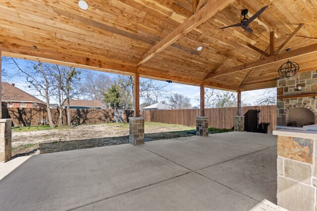 view of patio with an outdoor stone fireplace and a fenced backyard