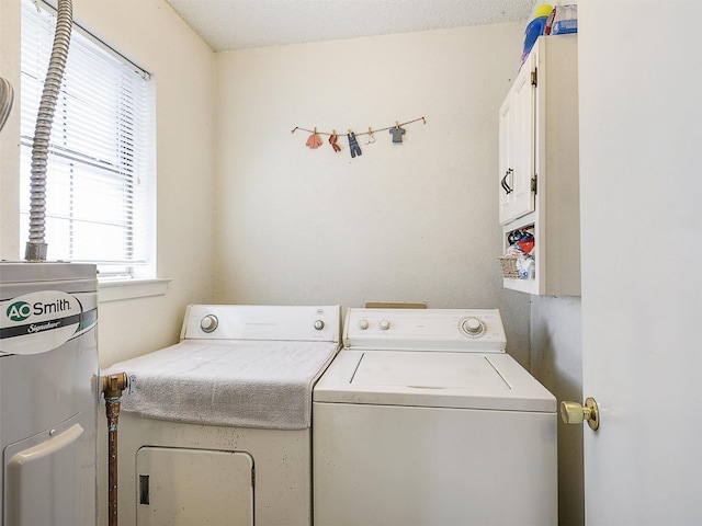 washroom with cabinet space, washing machine and clothes dryer, and electric water heater