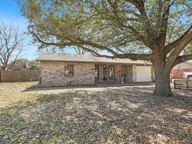 view of front of house with brick siding, fence, and an attached garage