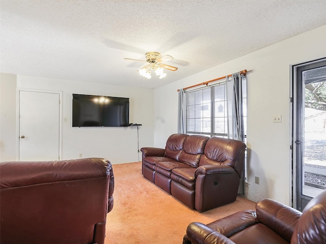 carpeted living room with ceiling fan and a textured ceiling