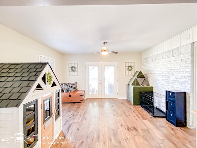 living room featuring light wood-style floors, french doors, baseboards, and a ceiling fan