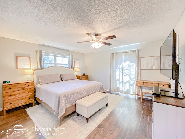 bedroom featuring a ceiling fan, a textured ceiling, and wood finished floors