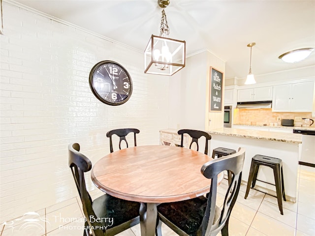 dining space featuring ornamental molding and light tile patterned flooring