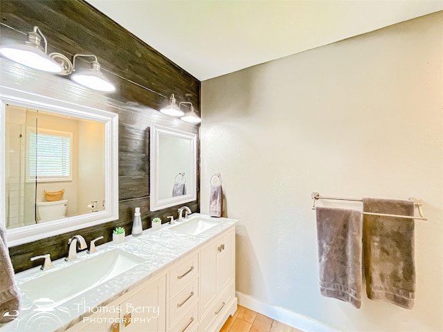 full bathroom featuring wood finished floors, a sink, toilet, and double vanity