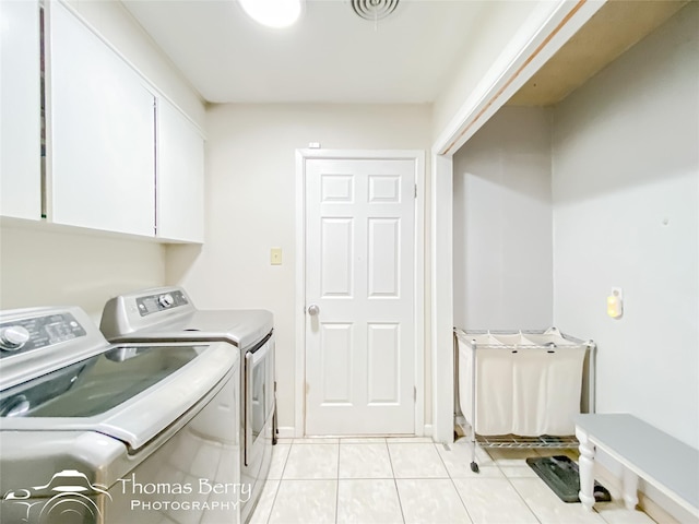 clothes washing area with cabinet space, visible vents, washer and dryer, and light tile patterned flooring