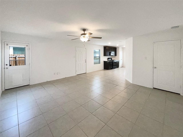 interior space with tile patterned flooring, visible vents, and ceiling fan