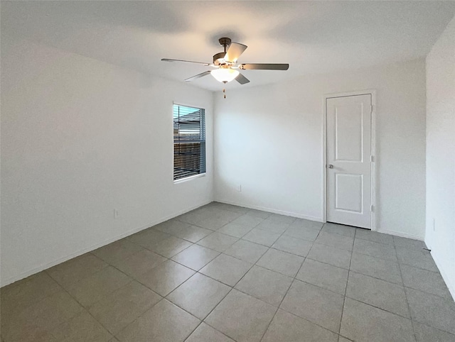 spare room with ceiling fan, baseboards, and light tile patterned floors