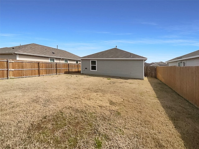 rear view of property featuring a fenced backyard