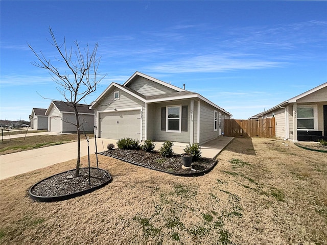 view of front facade with an attached garage, fence, and concrete driveway