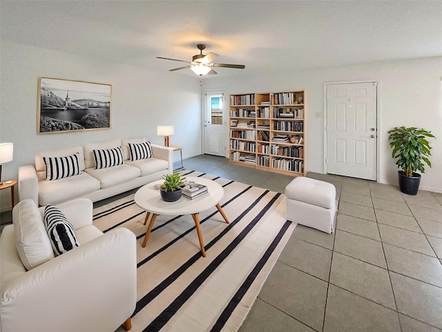 living area featuring tile patterned flooring and ceiling fan