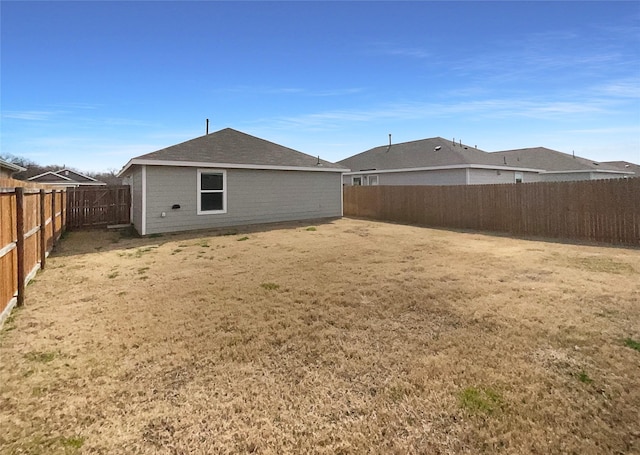 back of house with a fenced backyard