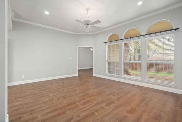 spare room featuring a ceiling fan, baseboards, crown molding, and wood finished floors