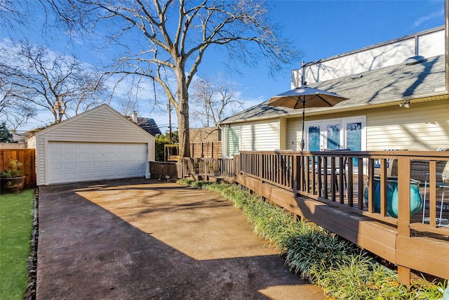 view of yard featuring a garage, an outdoor structure, a deck, and fence