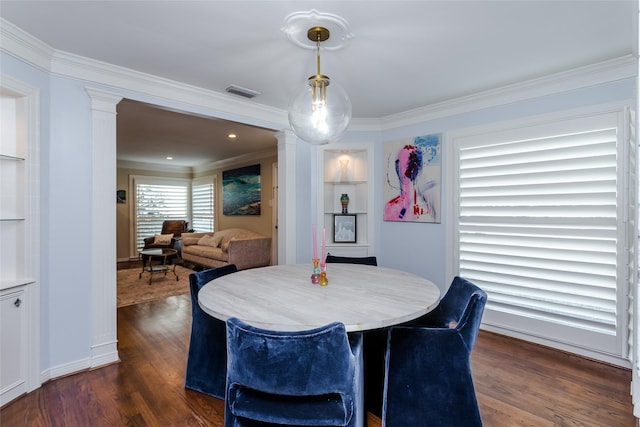 dining room with dark wood-type flooring, visible vents, built in features, ornate columns, and crown molding