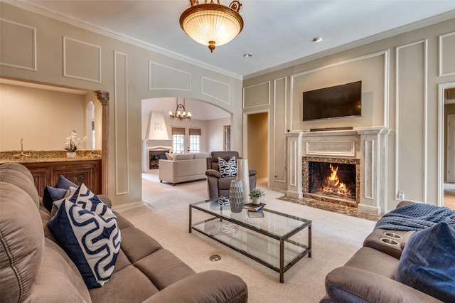 living room with arched walkways, carpet flooring, a fireplace, and a decorative wall