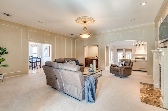 living area with arched walkways, crown molding, light colored carpet, and a decorative wall