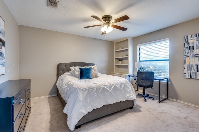 bedroom featuring ceiling fan, a textured ceiling, light colored carpet, visible vents, and baseboards