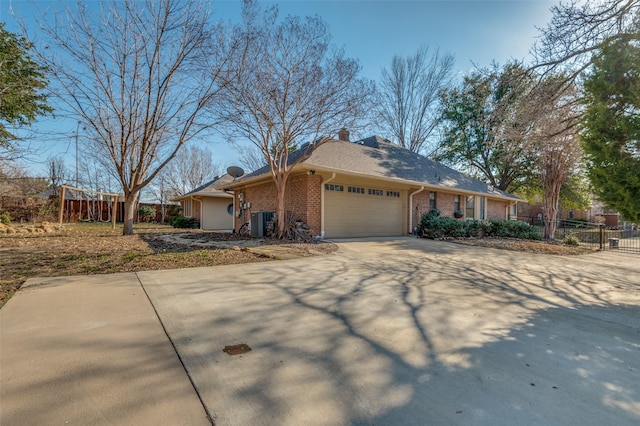 view of front facade featuring a garage, central AC, brick siding, fence, and concrete driveway