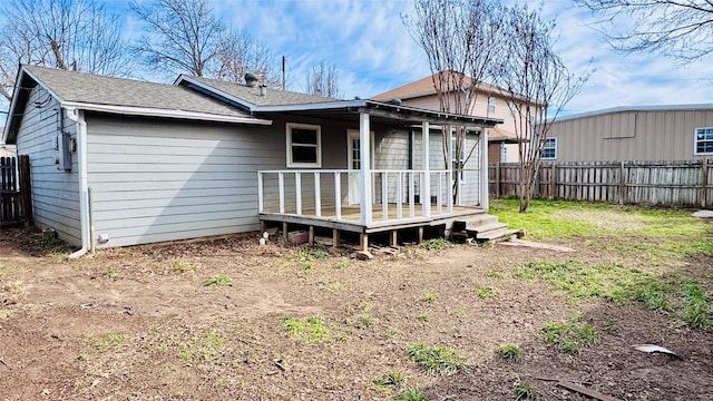 rear view of house with fence and a wooden deck