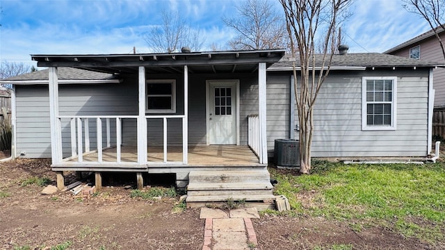 back of house with a shingled roof and central air condition unit