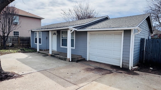 view of front of property with a garage, driveway, a shingled roof, and fence