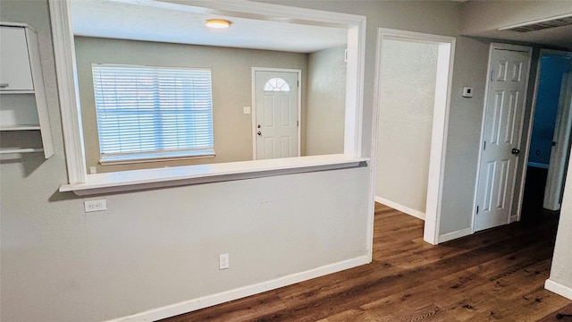 interior space featuring baseboards, visible vents, and dark wood-style flooring