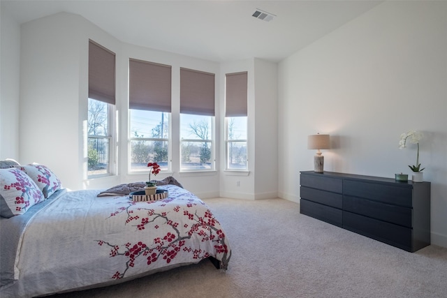 bedroom featuring carpet floors, multiple windows, visible vents, and baseboards