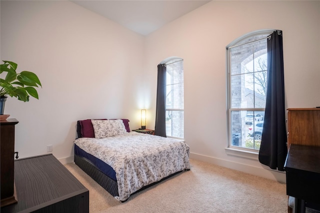 bedroom featuring carpet floors, multiple windows, and baseboards