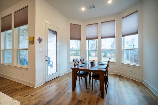 dining room featuring recessed lighting, visible vents, a wealth of natural light, and wood finished floors