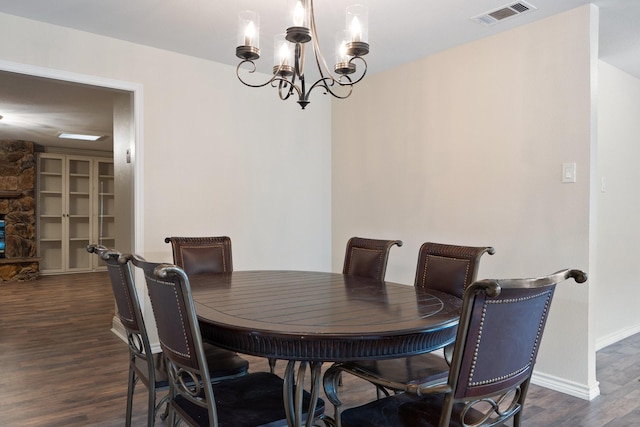 dining space with baseboards, visible vents, a chandelier, and dark wood-style flooring