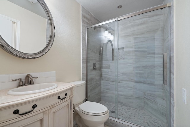 full bath featuring toilet, a shower stall, and vanity