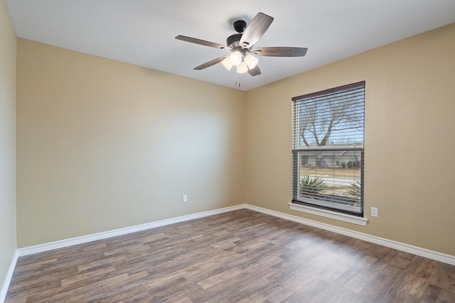 spare room featuring ceiling fan, baseboards, and wood finished floors